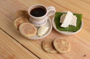 arepa de trigo venezolana con queso cuajado y taza de café caliente