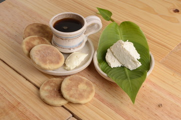 arepa de trigo venezolana con queso cuajado y taza de café caliente