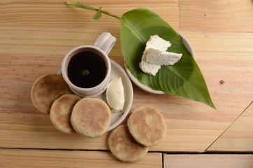 arepa de trigo venezolana con queso cuajado y taza de café caliente