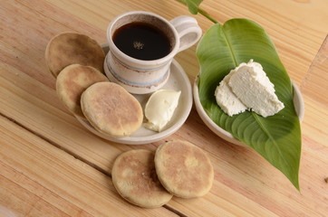 arepa de trigo venezolana con queso cuajado y taza de café caliente
