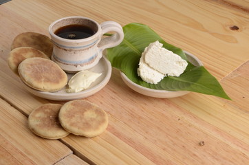 arepa de trigo venezolana con queso cuajado y taza de café caliente