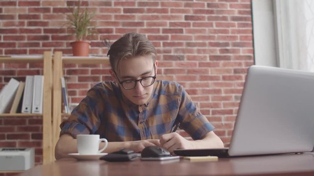 The guy writes off the data in a notebook from a laptop. A student writes off a couple's schedule from a laptop