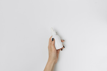 Cropped shot of woman with hands and bottle of lotion isolated on white