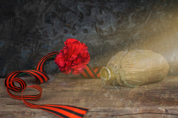 George Ribbon, aluminum flask and carnation. Still life, greeting card design. Concept Victory Day, May 9, toned, vintage. Copy space.