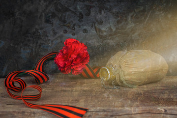 George Ribbon, aluminum flask and carnation. Still life, greeting card design. Concept Victory Day, May 9, toned, vintage. Copy space.
