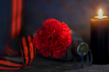 George Ribbon, aluminum flask, carnation and burning candle. Still life, greeting card design....