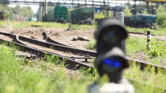 4k footage of camera focusing from long cargo trains on railroad to semaphore with blue light. Concept of transportation and cargo using railways