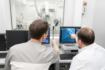 Doctors in front of a computer monitor of an x-ray machine. Hospital, modern medicine