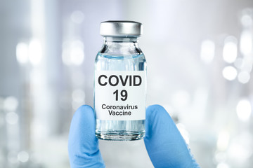 Healthcare cure concept with a hand in blue medical gloves holding Coronavirus, Covid 19 virus,...