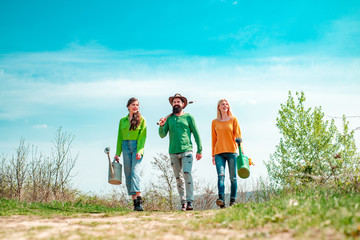 Funny friends walking in spring garden. Friends working in garden. Teamwork and friends...