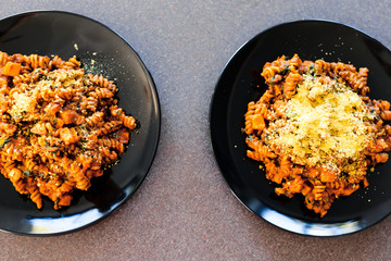 vegan fusilli pasta with lentils pumpkin cubes and kale topped with nutritional yeast