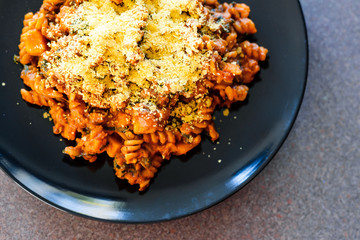 vegan fusilli pasta with lentils pumpkin cubes and kale topped with nutritional yeast