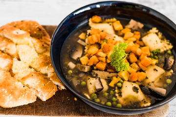 vegan ravioli with vegetable broth peas and pumpkin and side of garlic bread