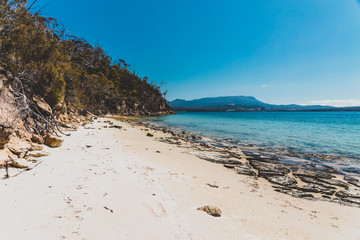 wild Tasmanian landscape and pristine turquoise water of the Derwent River as seen from Legacy Beach