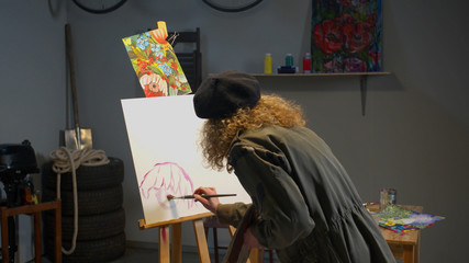 Woman paints a picture in the studio