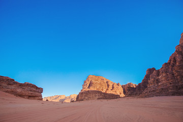 Fototapeta na wymiar Textured sand mountains of red and orange sand against the blue sky, Jordan, Wadi Rum desert.