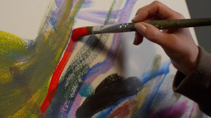 Woman draws a picture with paints, close up