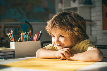 Cute face of pupil, close up. Pupil learning letters and numbers. Children learning. Cute child boy in classroom near blackboard desk.