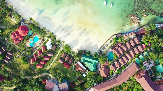 Tropical luxury resorts and hotels on the sandy coast of azure sea. aerial high angle.