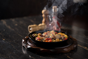 potatoes with mushrooms in a pan from the pan there is steam, a beautiful fucking dishes