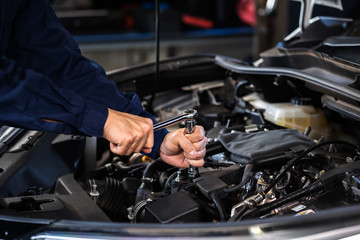 Fototapeta na wymiar mechanic hand using wrench to repair engine, car service