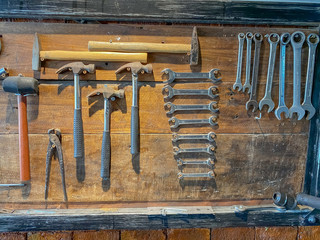 old tools of technician hanging on wooden board