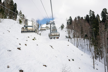 People are lifting on ski-lift in the mountains in winter