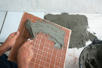 Technicians are putting cement on ceramic, technicians prepare tiles for paving on cement floors