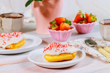 Breakfast with sweet sprinkle donut, strawberry and cup of coffee.