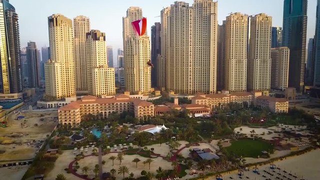 Powered paragliding paramotoring ppg flight with parachute on magnificent aerial Dubai beach modern building cityscape