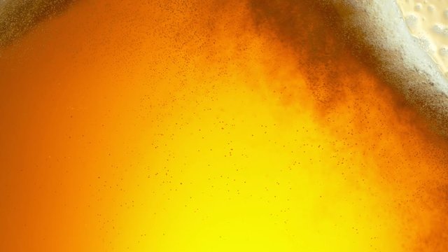 Super slow motion of macro shot of beer drink, close-up. Filmed on high speed cinema camera, 500 fps.