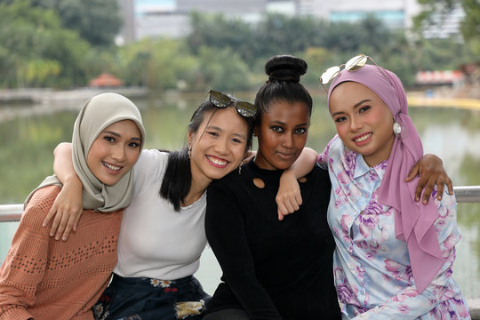 Group of woman Malay Chinese Indian Malaysian  hug friends togetherness unity outdoor green park lake nature