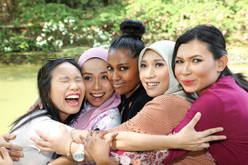 group of five woman friends Malay Chinese Indian Asian outdoor park lake nature hugging caring...