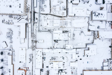 aerial top view of snow-covered roofs of industrial buildings in winter 
