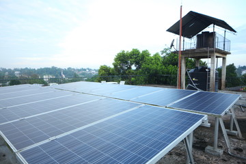 Solar panels on the roof of a tropical city house early in the morning at dawn.