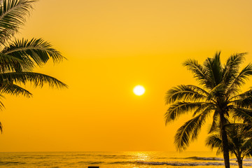 Naklejka na ściany i meble Beautiful nature with palm tree around sea ocean beach at sunset or sunrise