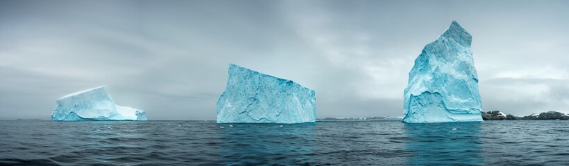 panorama with three giant icebergs in strait in Antarctica