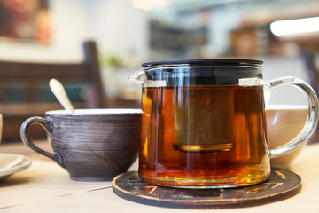 Cup and teapot on a table in a cafe.
