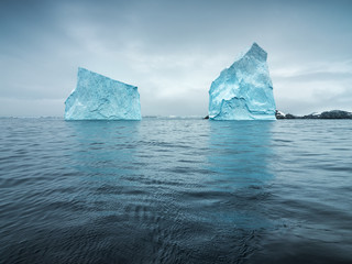 two blue icebergs in twilight in Antarctica