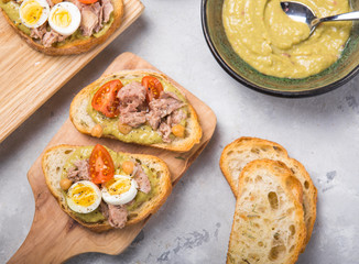 Bruschetta with tuna, tomato, egg, and avocado spread.