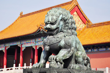 Chinese architecture in Beijing, a Chinese traditional lion with a mustache on the background of a yellow old roof with tiles