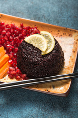 Thai diet food, Black Rice cooked with raw carrot, beetroot, pecan nuts, pomegranate and mint. Healthy vegan bowl. Top view with copy space.