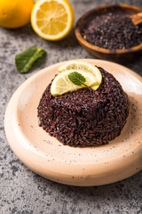 Cooked Thai black jasmine rice with chia seeds, lemon, sesame on concrete grey  background.