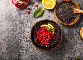 Cooked Thai black jasmine rice with chia seeds,pomegranate,  lemon, sesame on concrete grey  background. Top view copy sapce