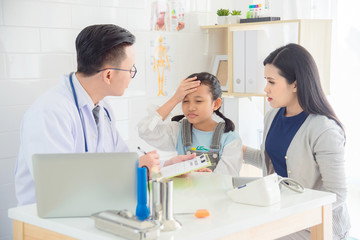 Young asian girl with headache and fever come to visit doctor with her mother at medical clinic.