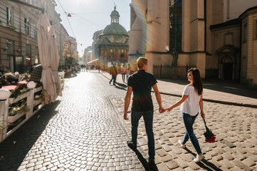 Loving happy couple go back. A man and a woman walk along the streets of the city.