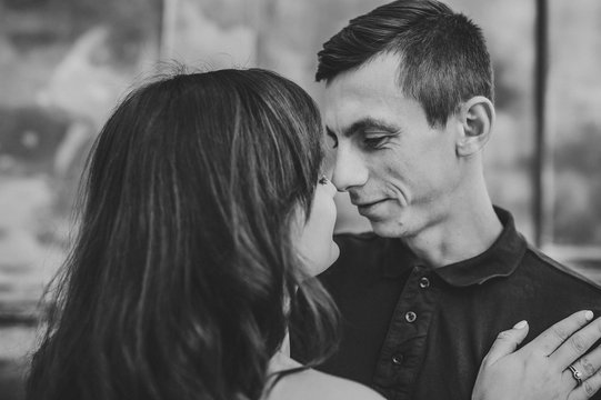 Loving young couple kissing and hugging in st valentine's day outdoors. Love and tenderness, dating, romance, family, anniversary concept. Black and white photo.