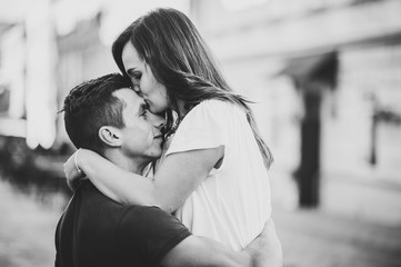 Loving young couple kissing and hugging in st valentine's day outdoors. Love and tenderness, dating, romance, family, anniversary concept. Black and white photo.