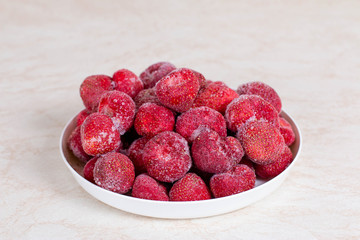 Frozen strawberries in a white plate