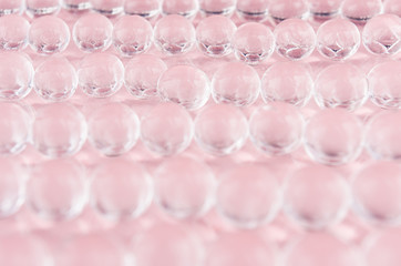 Abstract cosmetic background -  glass balls on pastel pink backdrop.